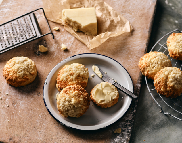 Plate of cheese scones with butter spread over them